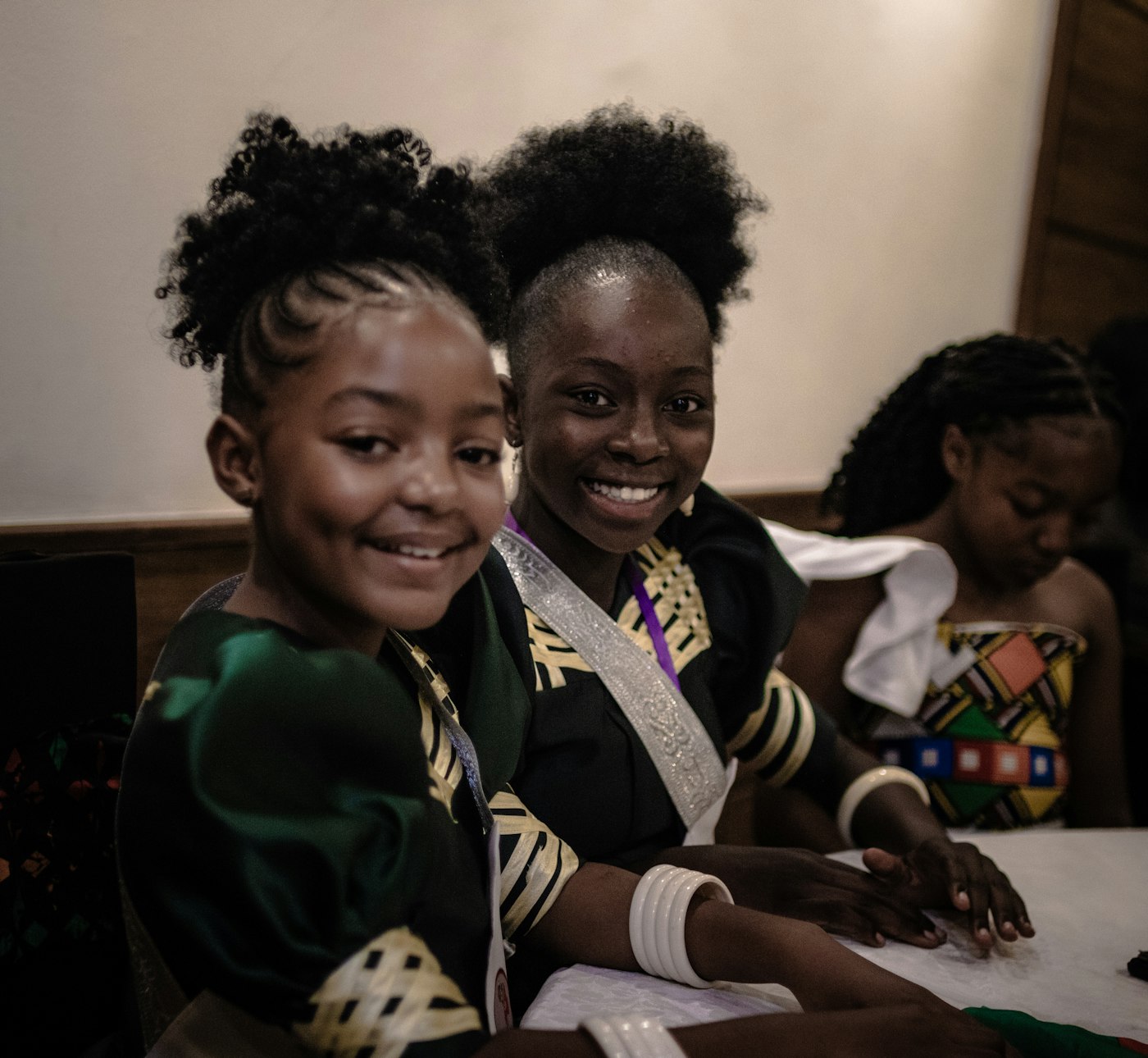 Two smiling girls sitting together